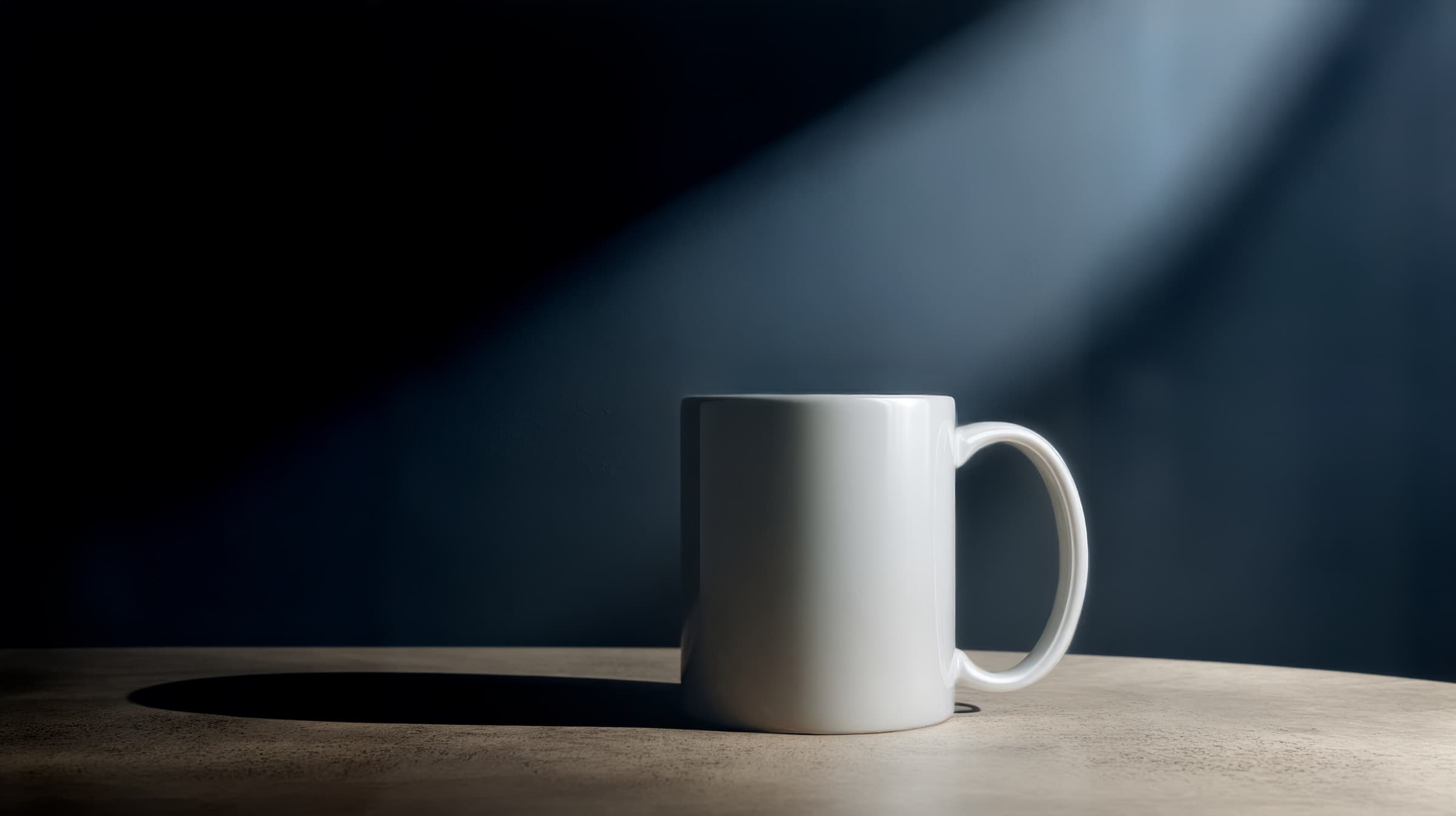 A white mug on a table in dramatic light